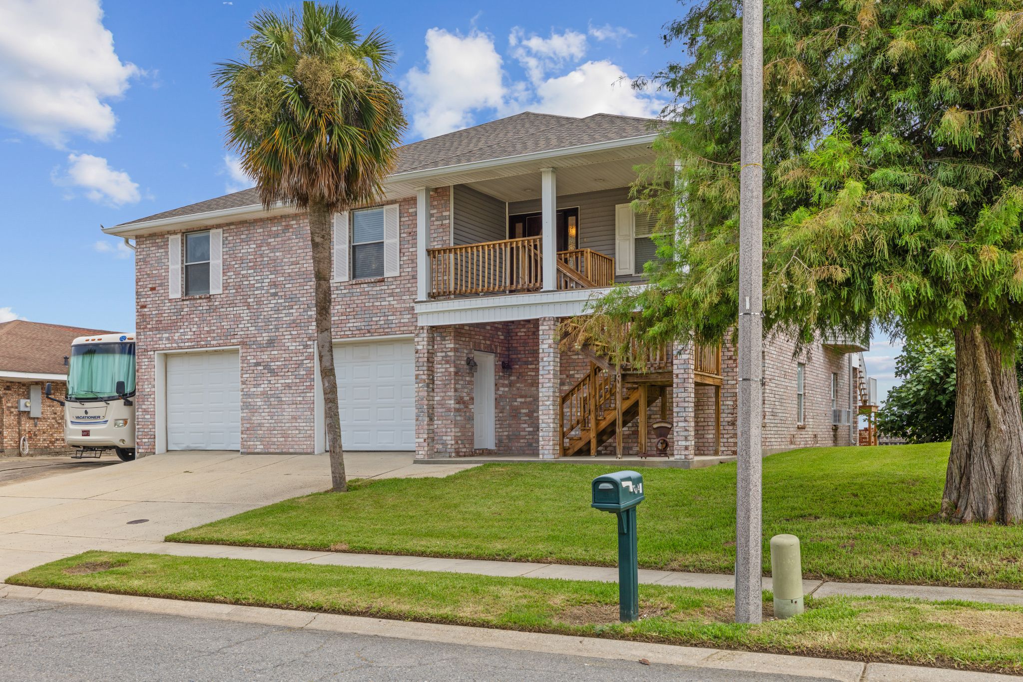 Front elevation with palms and covered parking below